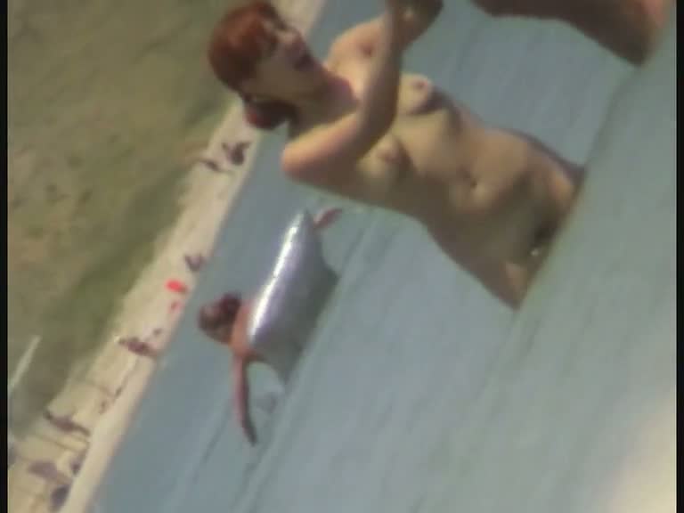 Beach spy cam catches a readhead girl running into the water