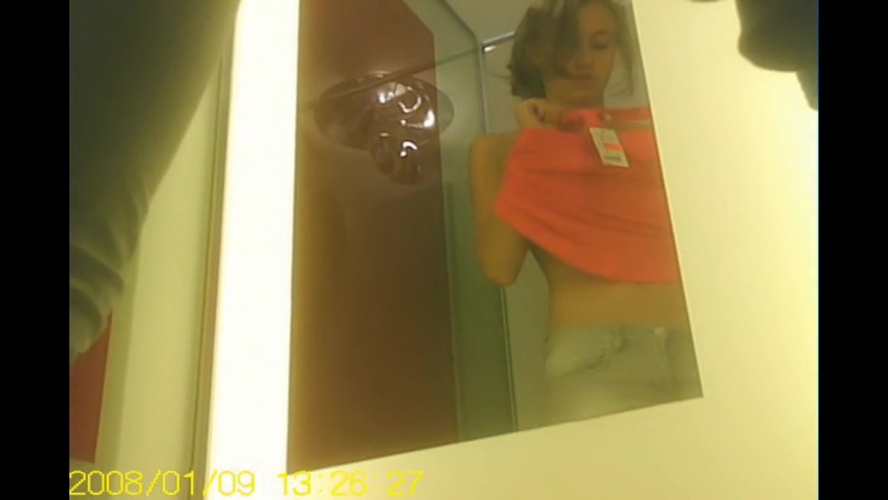 Girl in changing room admires her own reflection in mirror