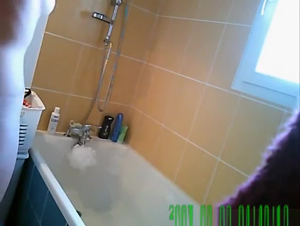 Woman washes her body in bathtub