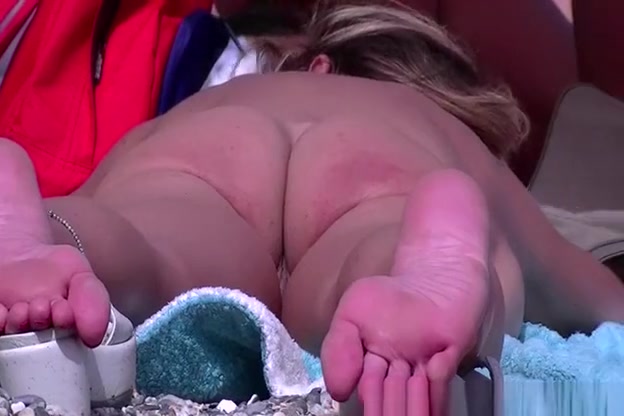 Nudist woman laid down on her belly sunbathing