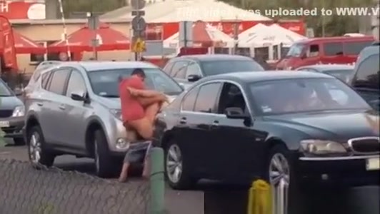Boy with girl having sex on a car in the bazaar.
