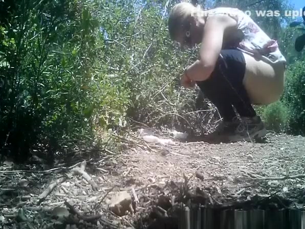 Blonde woman in sunglasses peeing in nature