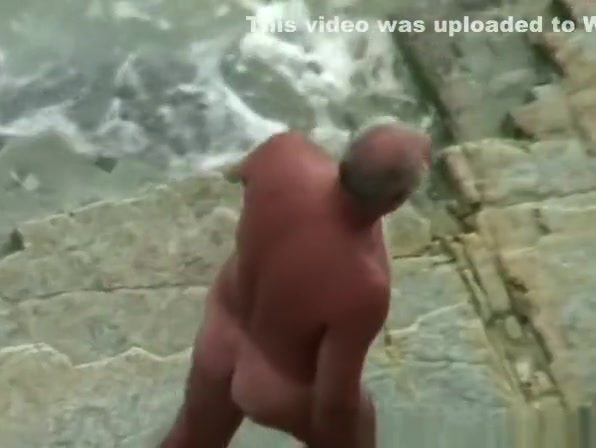 Voyeur hidden in the top of the cliff secretly film nudist couple