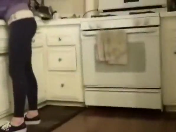 Girlfriend in leggings cleaning the kitchen
