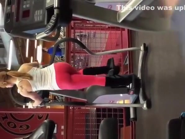 Tattooed blonde in red sports pants exercising