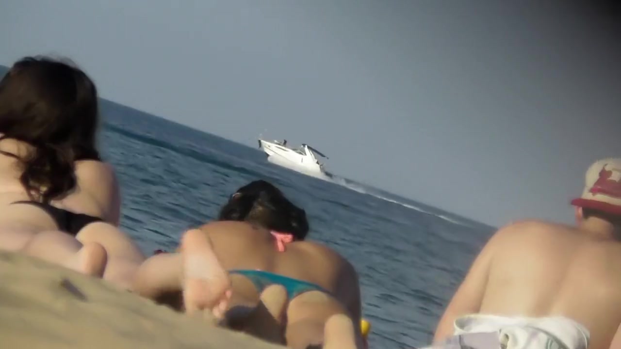 Asian teen girl bends over on beach