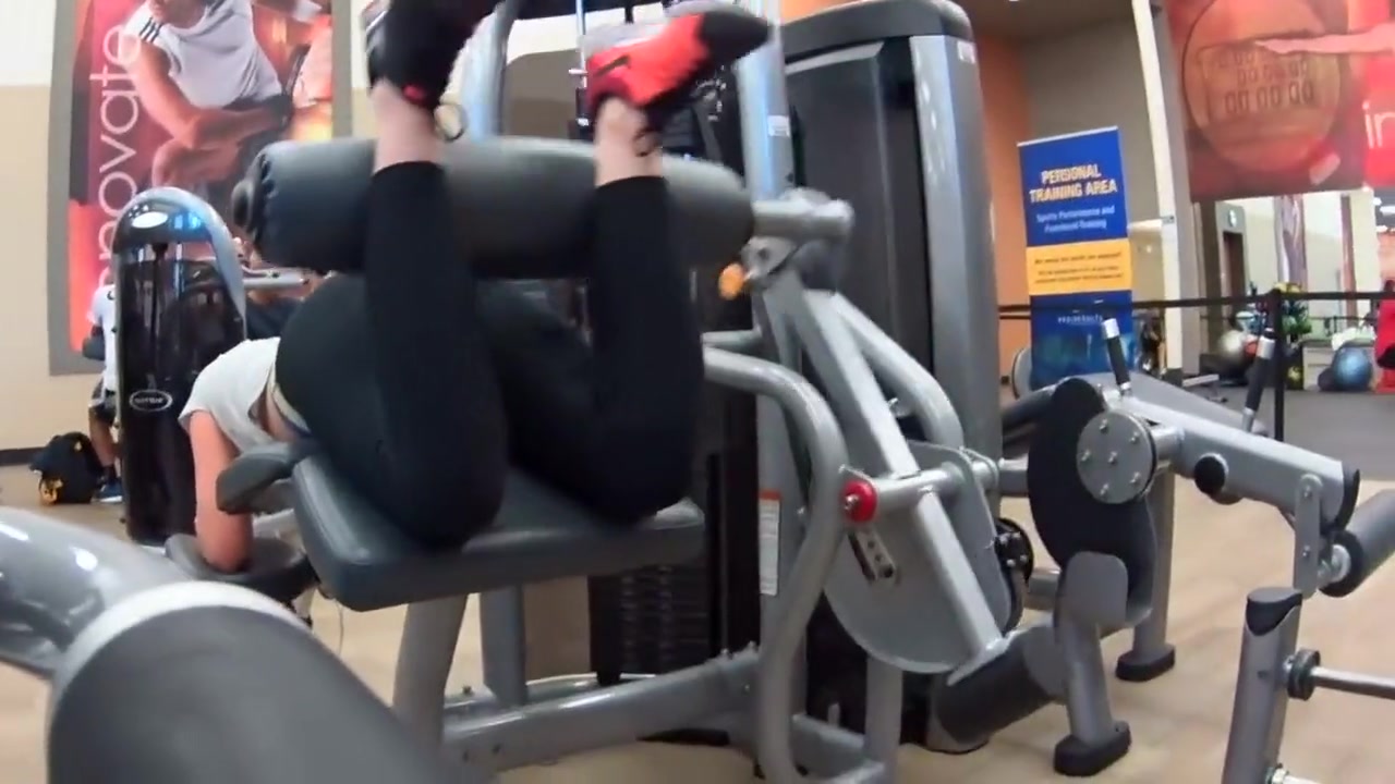 Sexy girl does leg curls in gym