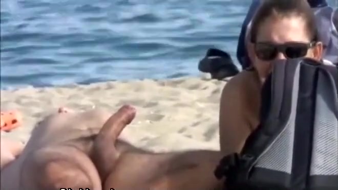 Wife strokes his half hard penis at the beach