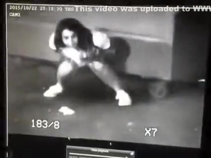 Surveillance camera films the desperate girl taking a piss
