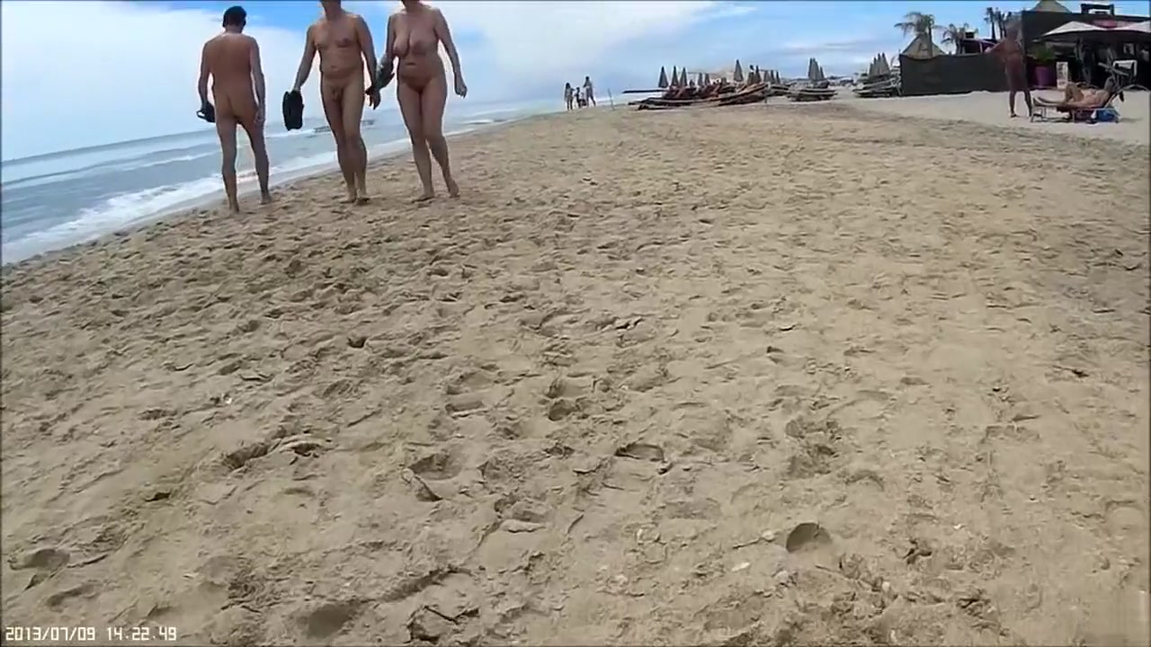 Older people walk around the beach completely naked