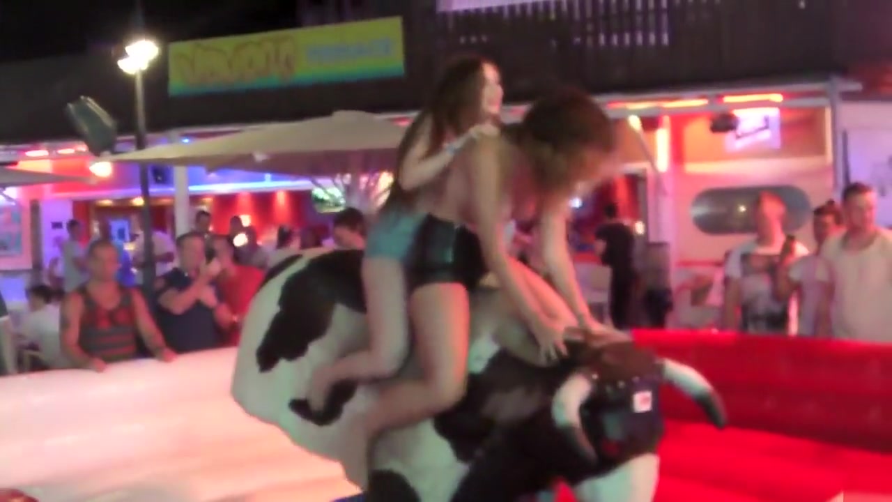 Two sexy chicks jumps on an mechanical bull while being topless
