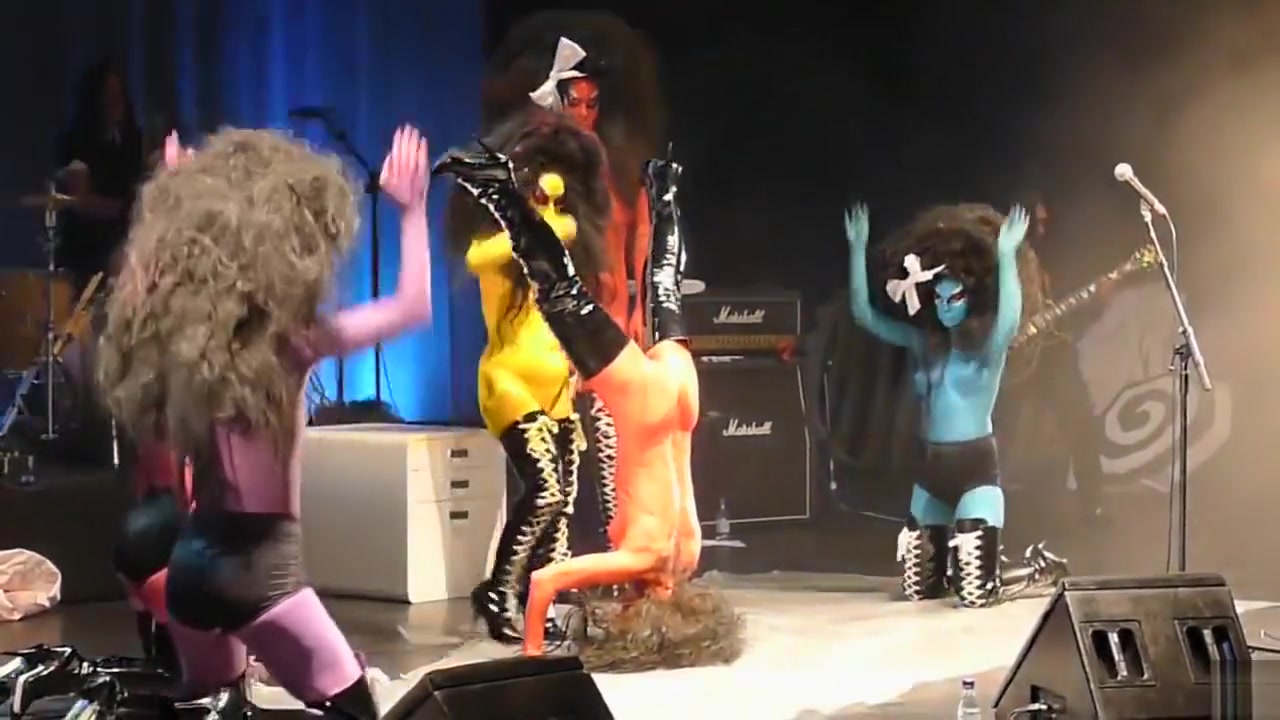 Painted boobs bounce around on the stage at a rock concert
