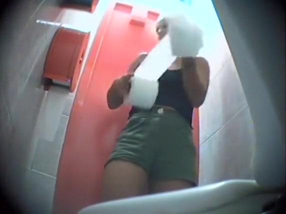 Fit woman in little shorts pees in a public toilet
