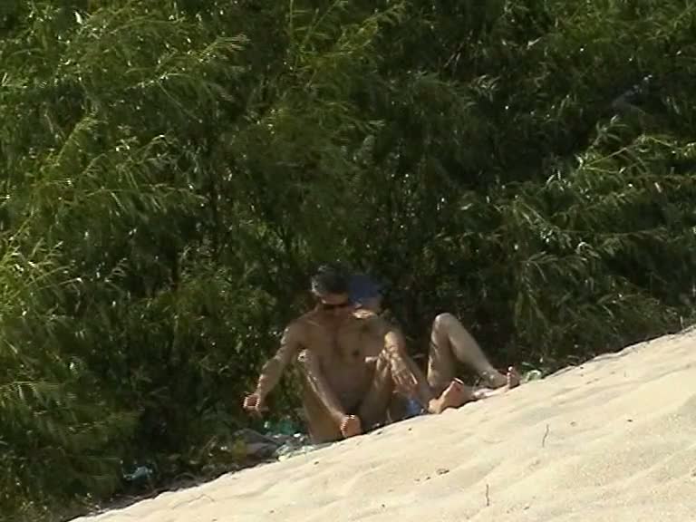 Spy camera on a nudist beach focuses on a sexy brunette