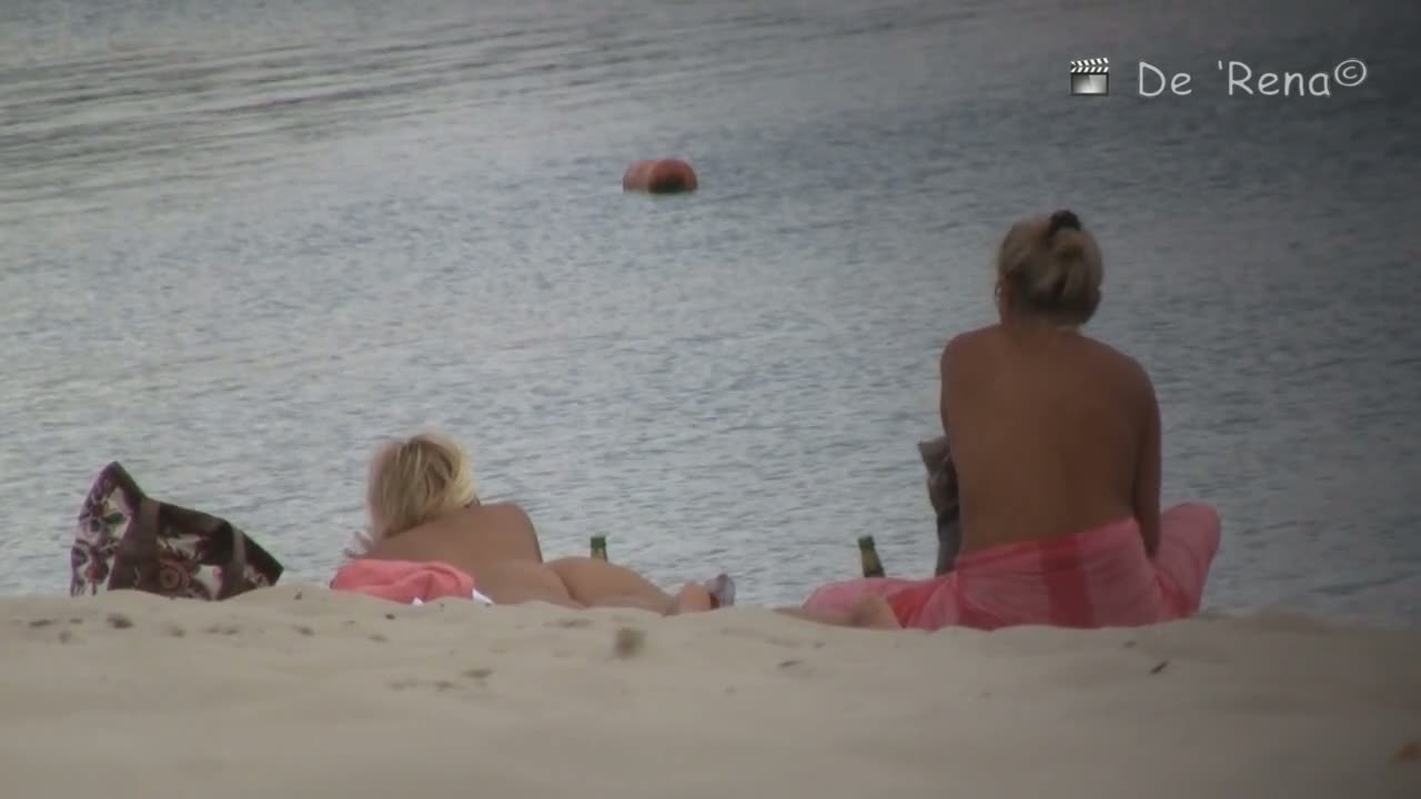 Voyeur spies on a perky breasted MILF on a nudist beach