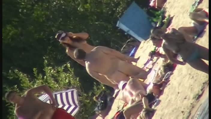 Hot brunette bares it all to the nudist beach voyeur