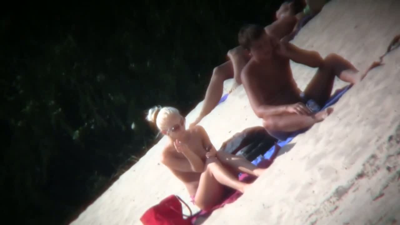 A couple sizzling hot blondes tanning in a nudist beach porno