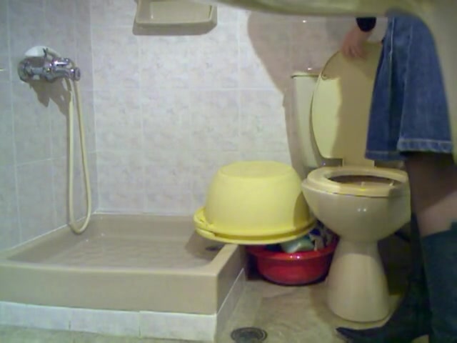 Amateur blonde looks into the bowl pissing on toilet