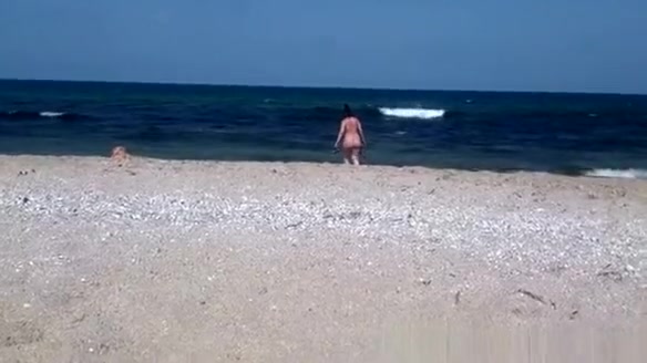 Pregnant nudist woman at beach